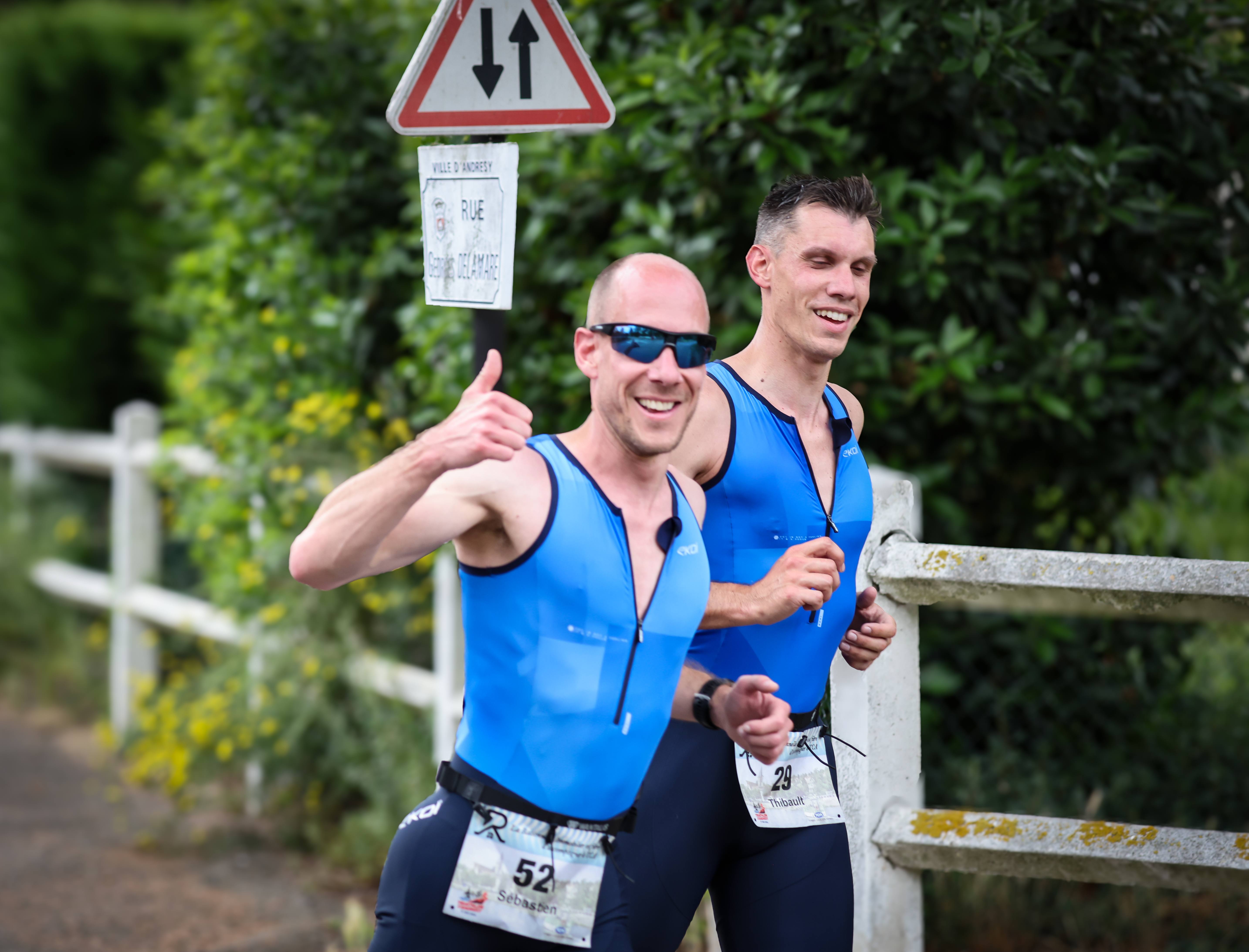 Deux duathlètes du TCA souriants sur la seconde course à pied, rue Georges Delamare